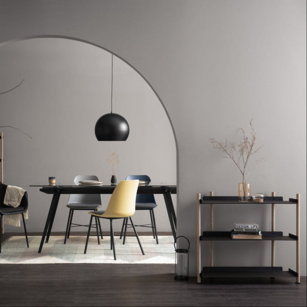 Modern dining room with a black dining table, chairs, and a pendant light.