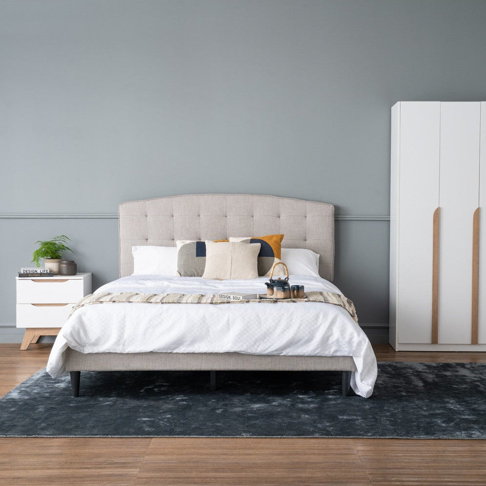 Modern bedroom with a bed, nightstand, and wardrobe against a gray wall.