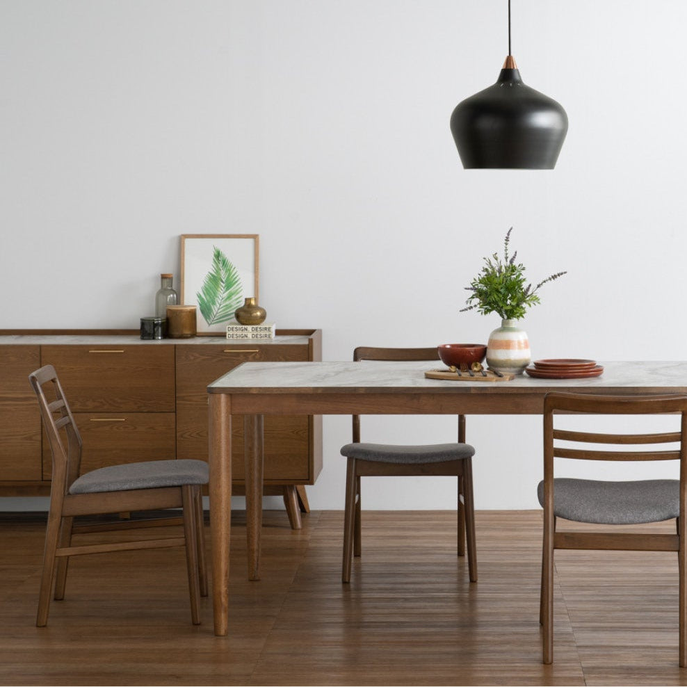 Dining table set with chairs in a room, featuring the Breda brand.