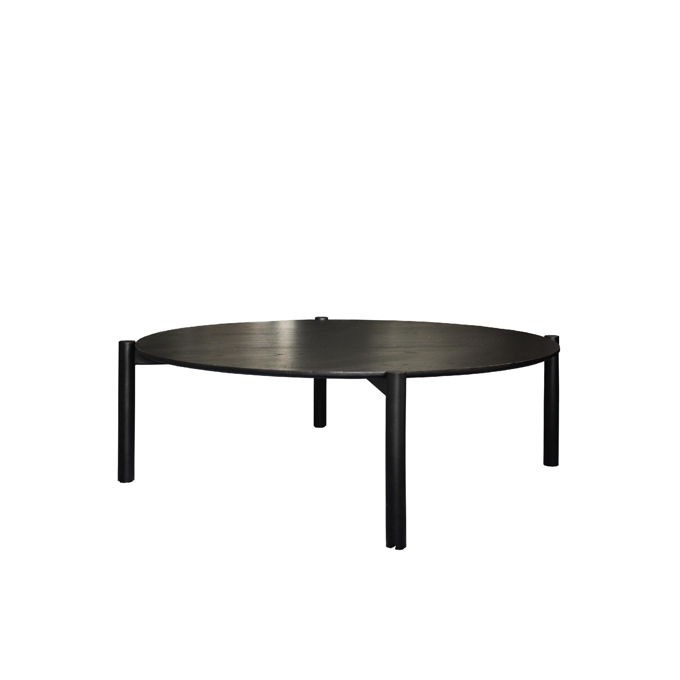 A black round coffee table with a textured top and metal legs.