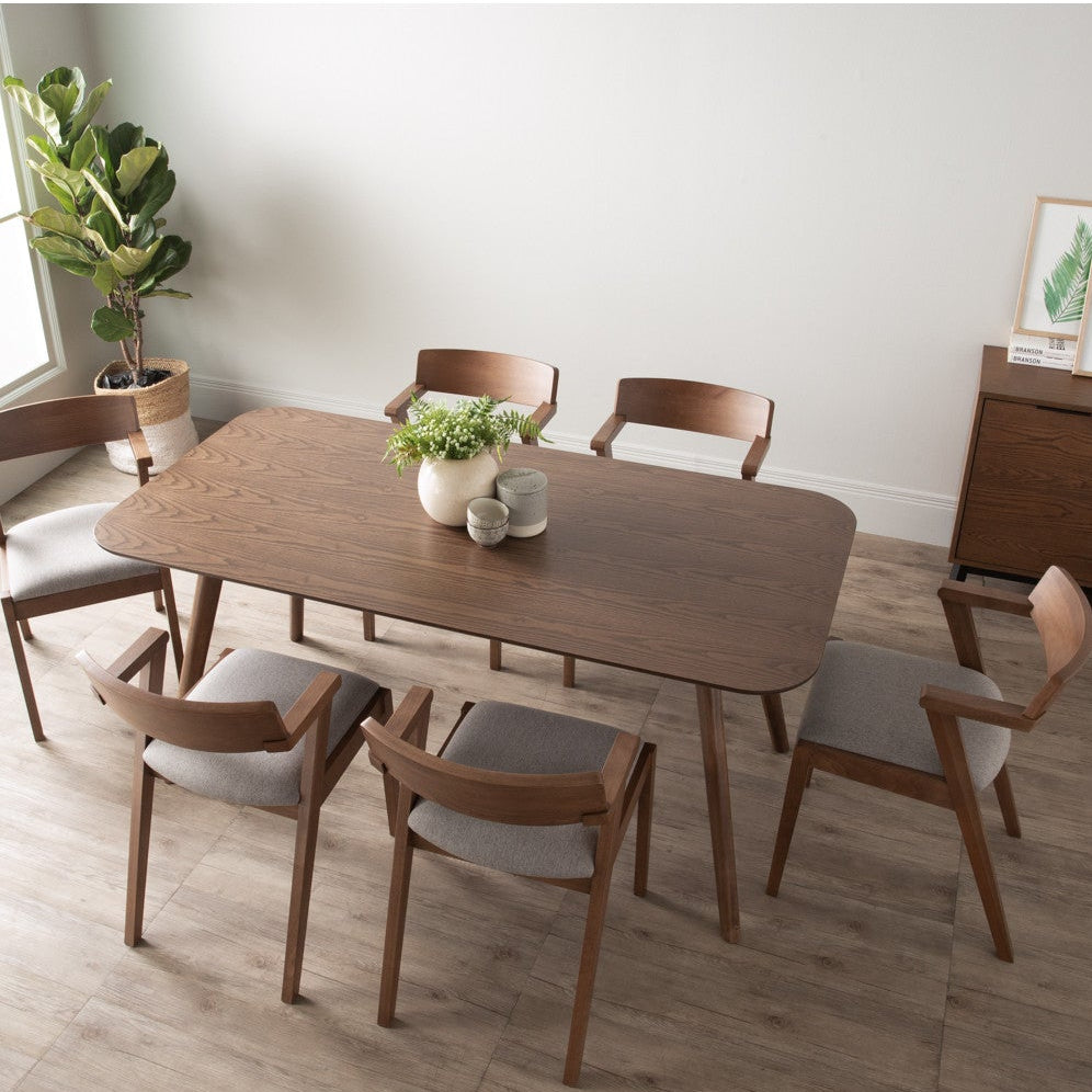 Dining room with wooden table and chairs in a bright room.
