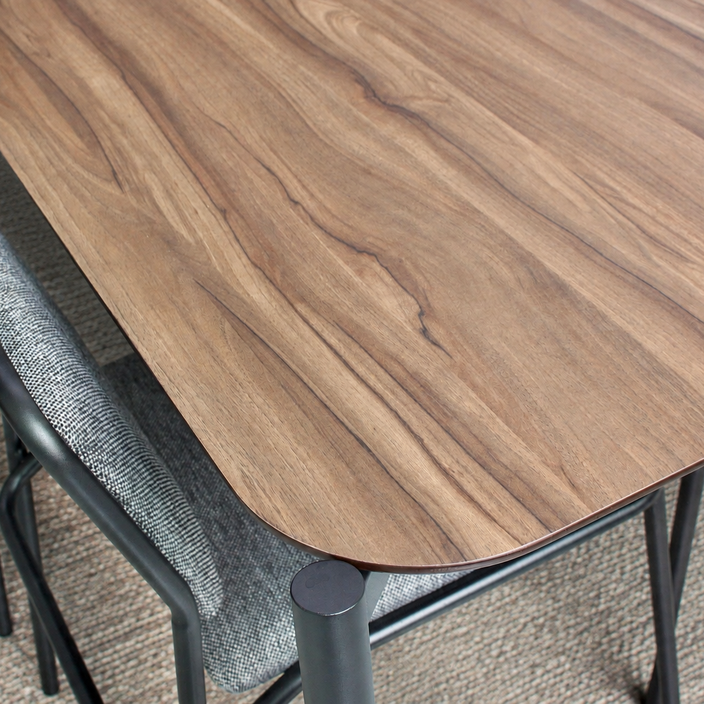Wooden table with metal legs and gray chairs on a carpeted floor