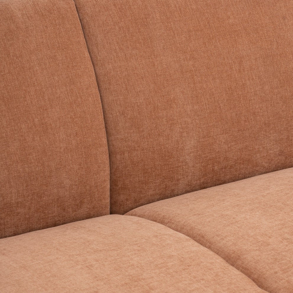 Close-up of a terracotta brown upholstered sofa showing the fabric texture, seat cushion, and back cushions.