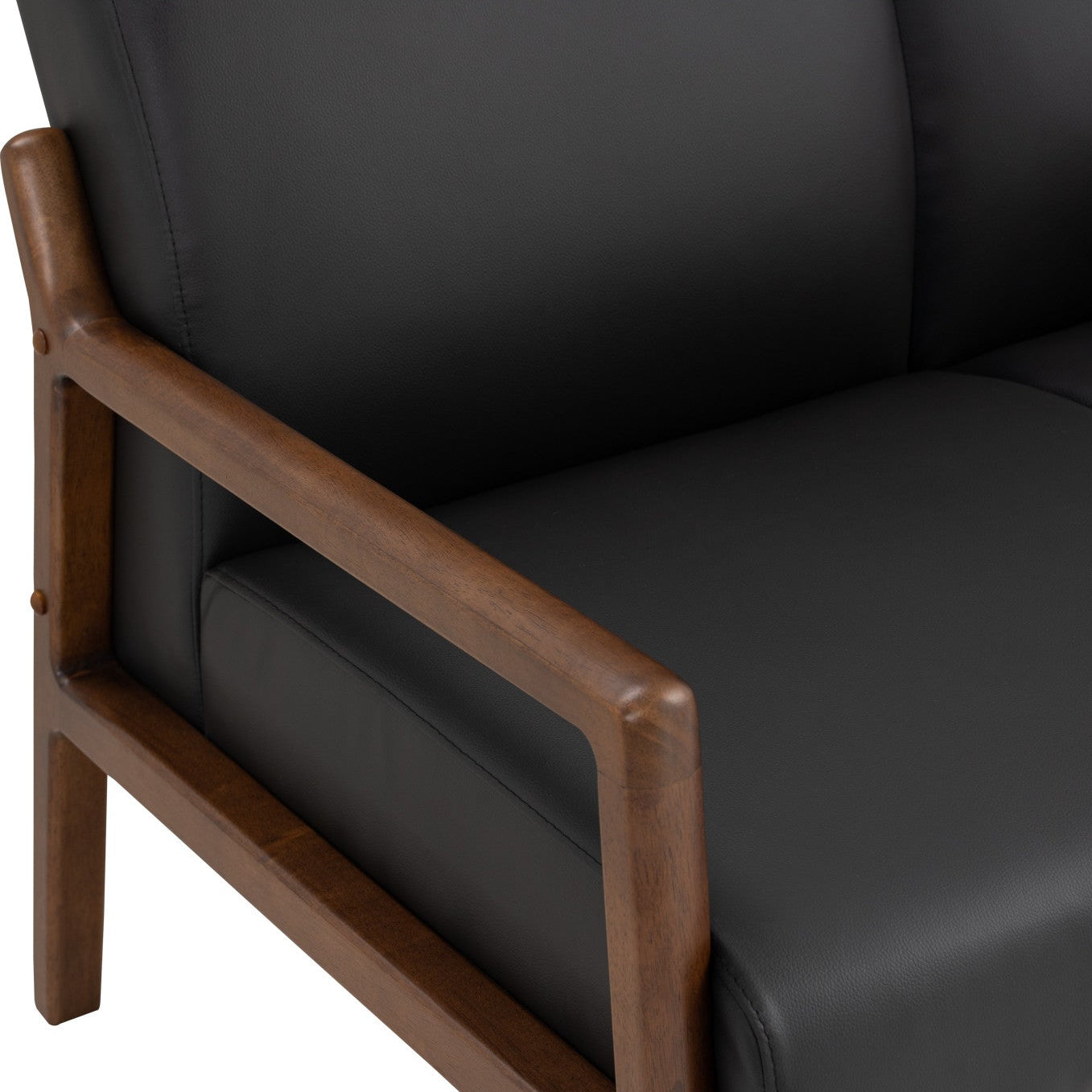 Close-up of a modern armchair with black upholstered seat and back cushions and a medium brown wooden frame.