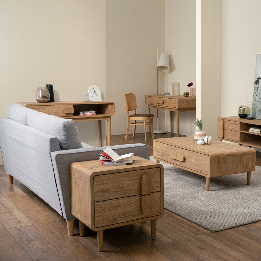 Modern living room with gray sofa, wooden coffee table, and side tables.