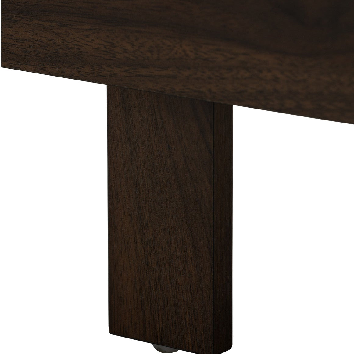 Close-up detail of a dark brown wooden furniture piece showing the corner of the top surface and a matching vertical leg on a white background.