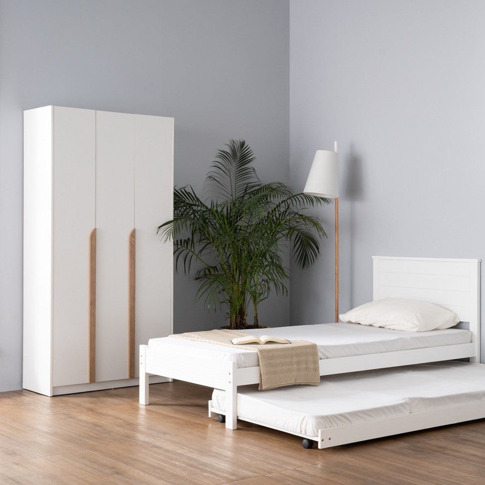 White bedroom furniture set with bed and wardrobe in a minimalistic room.