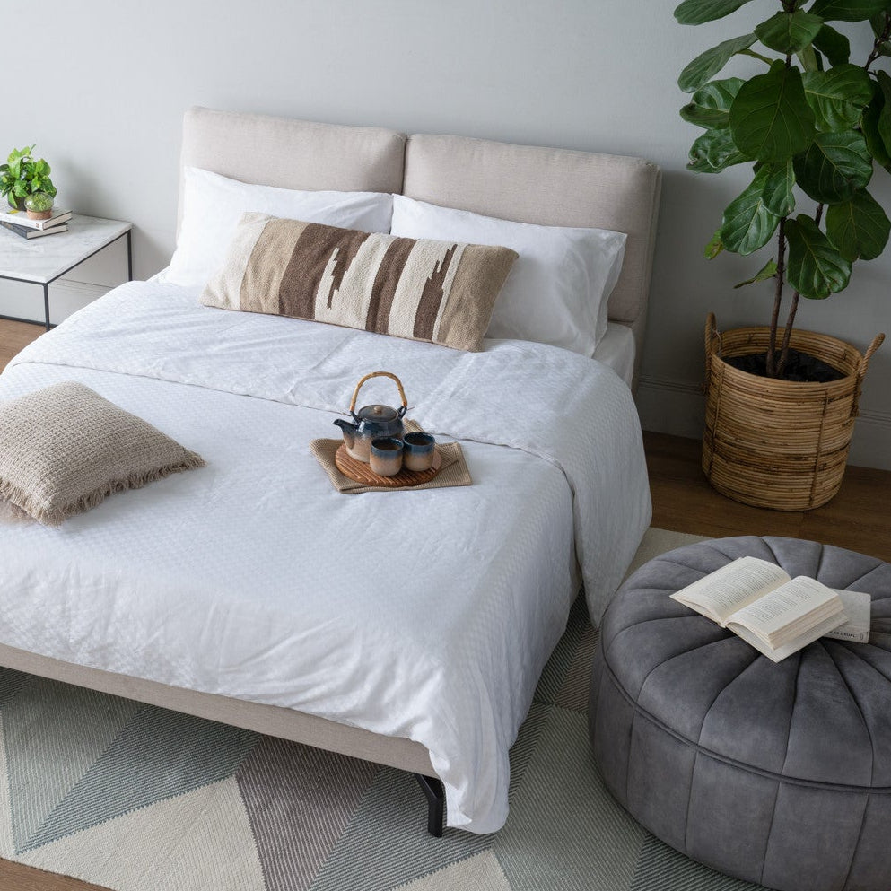 Modern bedroom with a bed, side table, and decorative items.