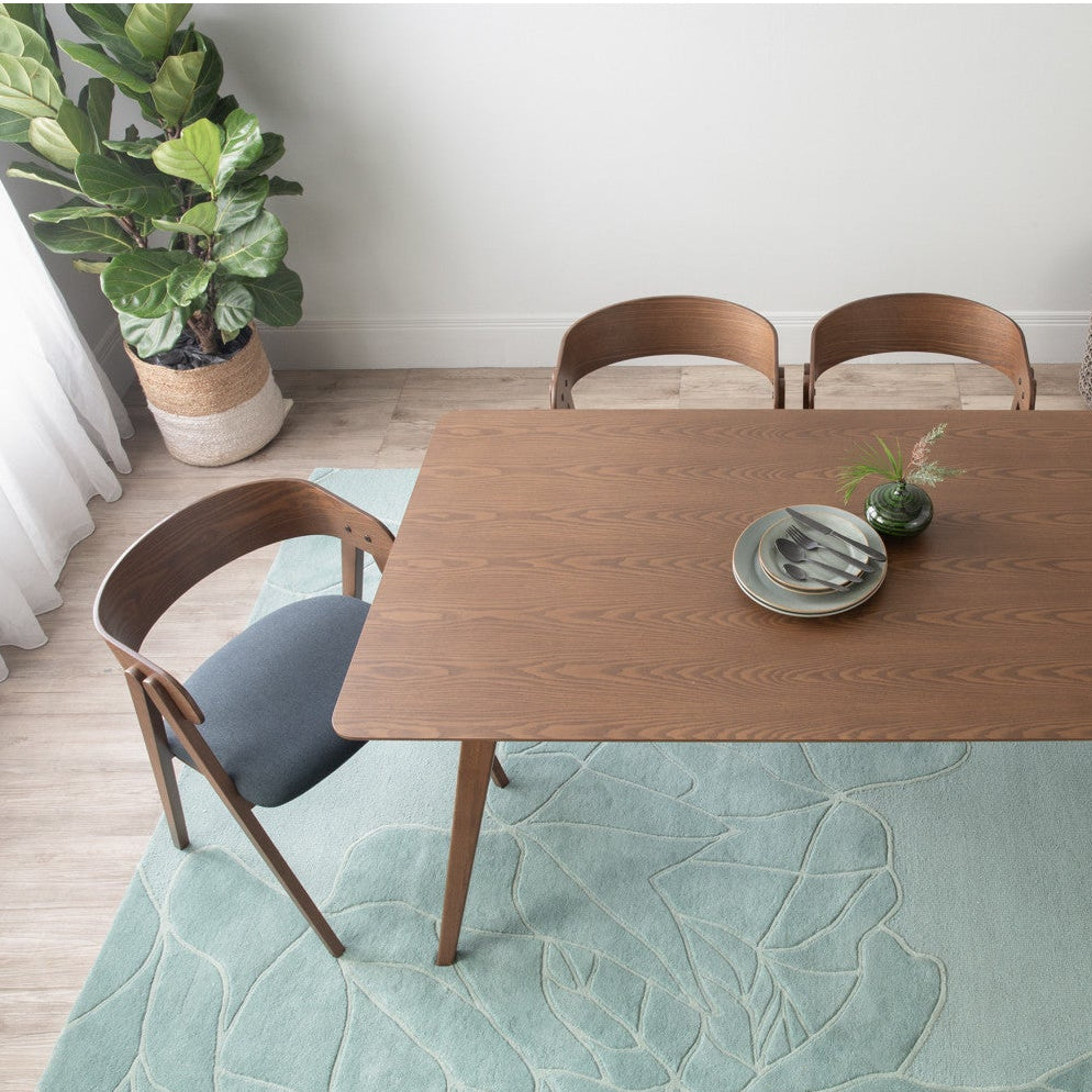 Dining room with wooden table and chairs on a green rug