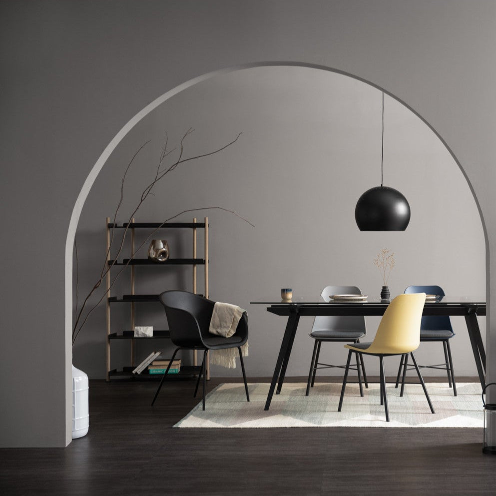 Modern dining room with a black dining table, chairs, and a pendant light.