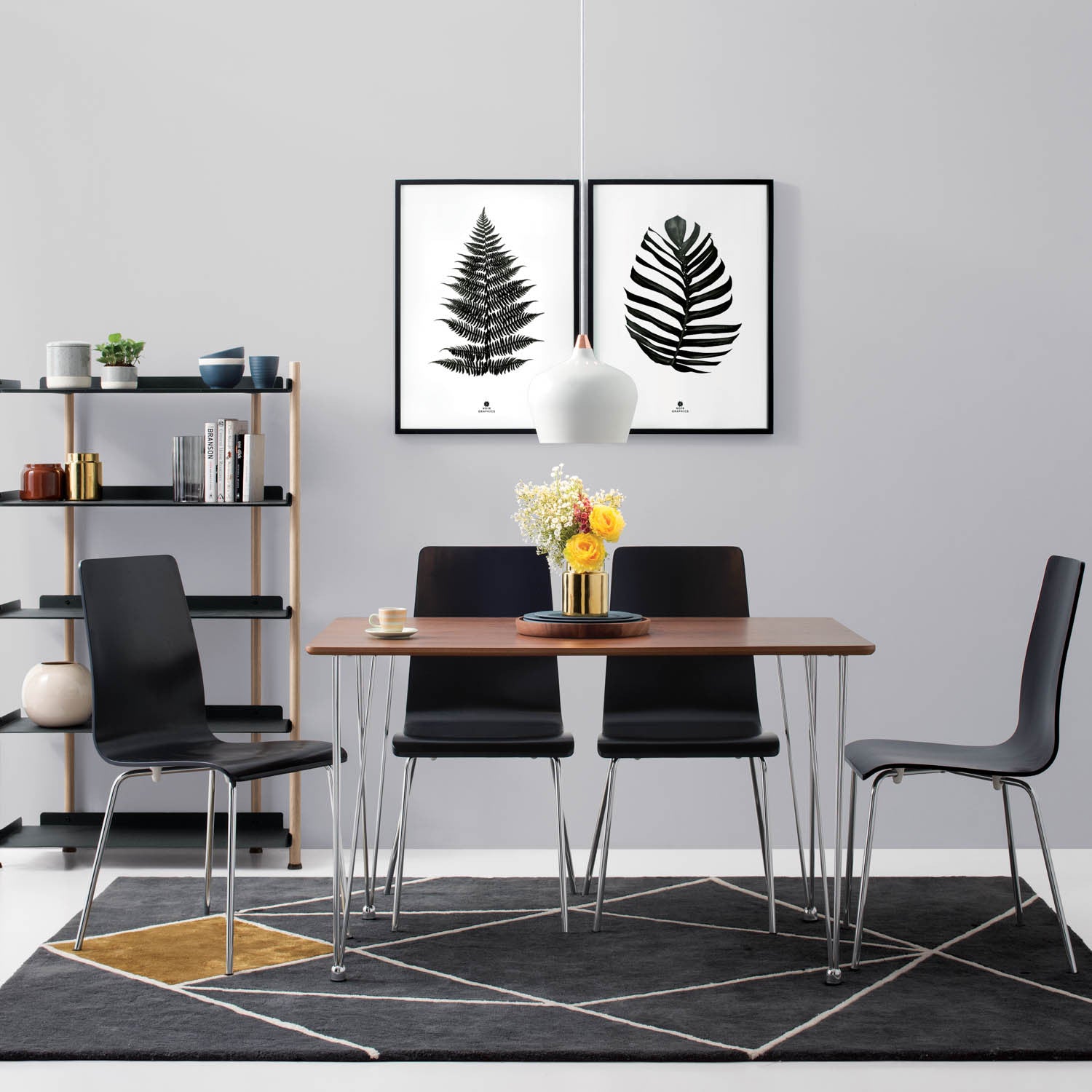 Dining area with a wooden table and black chairs, featuring wall art and a rug.