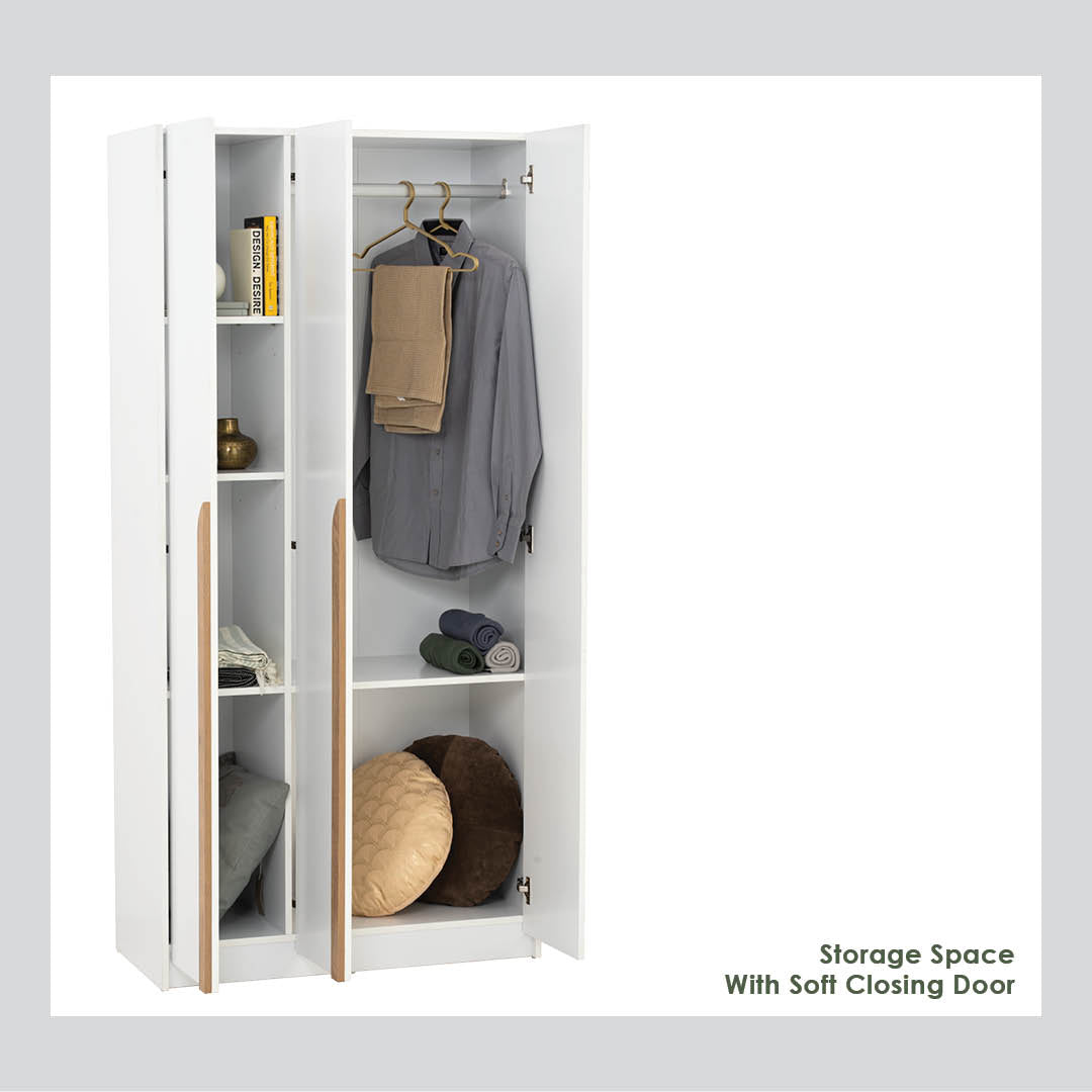 A white three-door storage wardrobe shown open, with shelves, a hanging rod, folded and hung garments, and storage pockets. The wardrobe has light wood handles and is photographed on a white background with text reading 'Storage Space With Soft Closing Door' in the lower right.