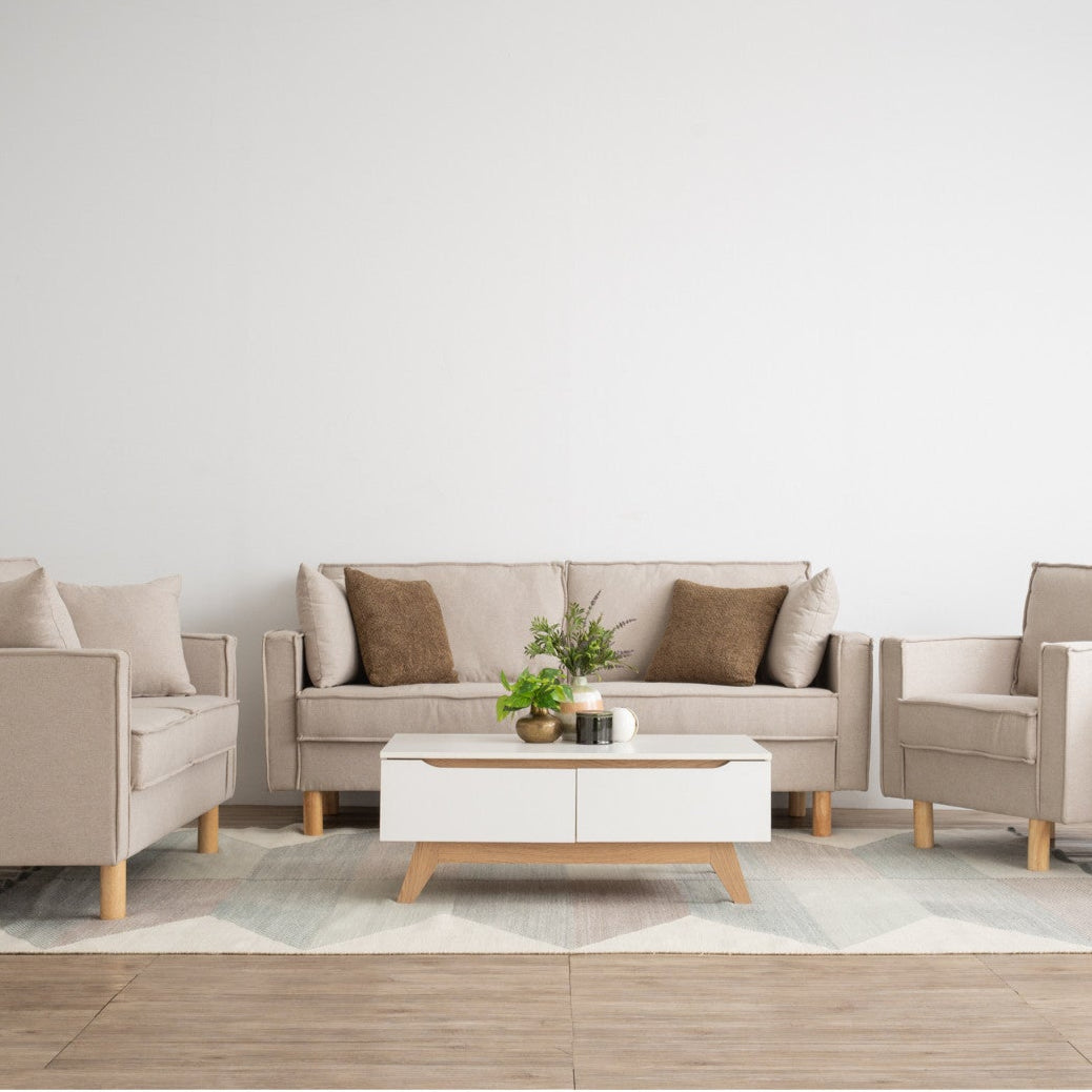 Modern living room with beige sofa, armchairs, and coffee table on a light wood floor.