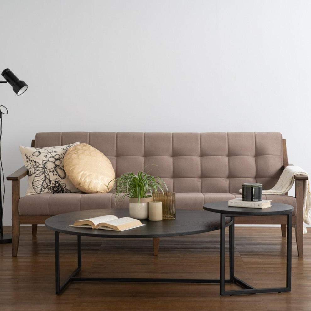 Modern living room with a beige sofa, coffee table, and decorative items.