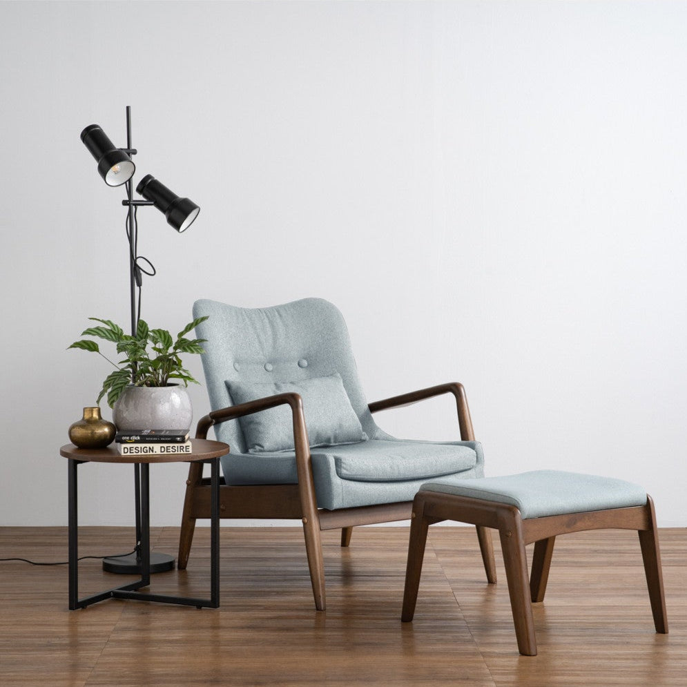 Modern armchair with ottoman and side table in a minimalistic room.