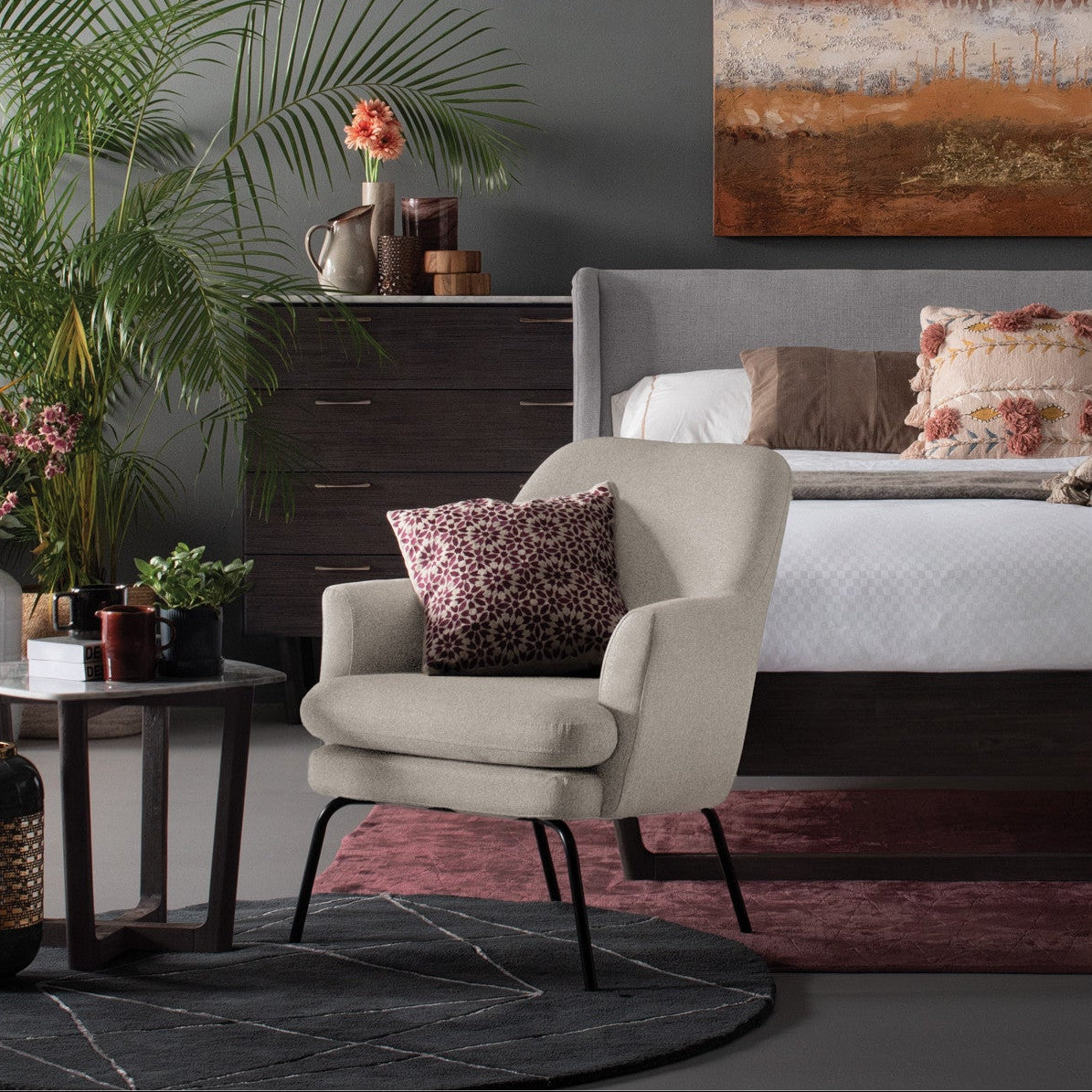 Modern bedroom with a bed, armchair, and decorative elements.