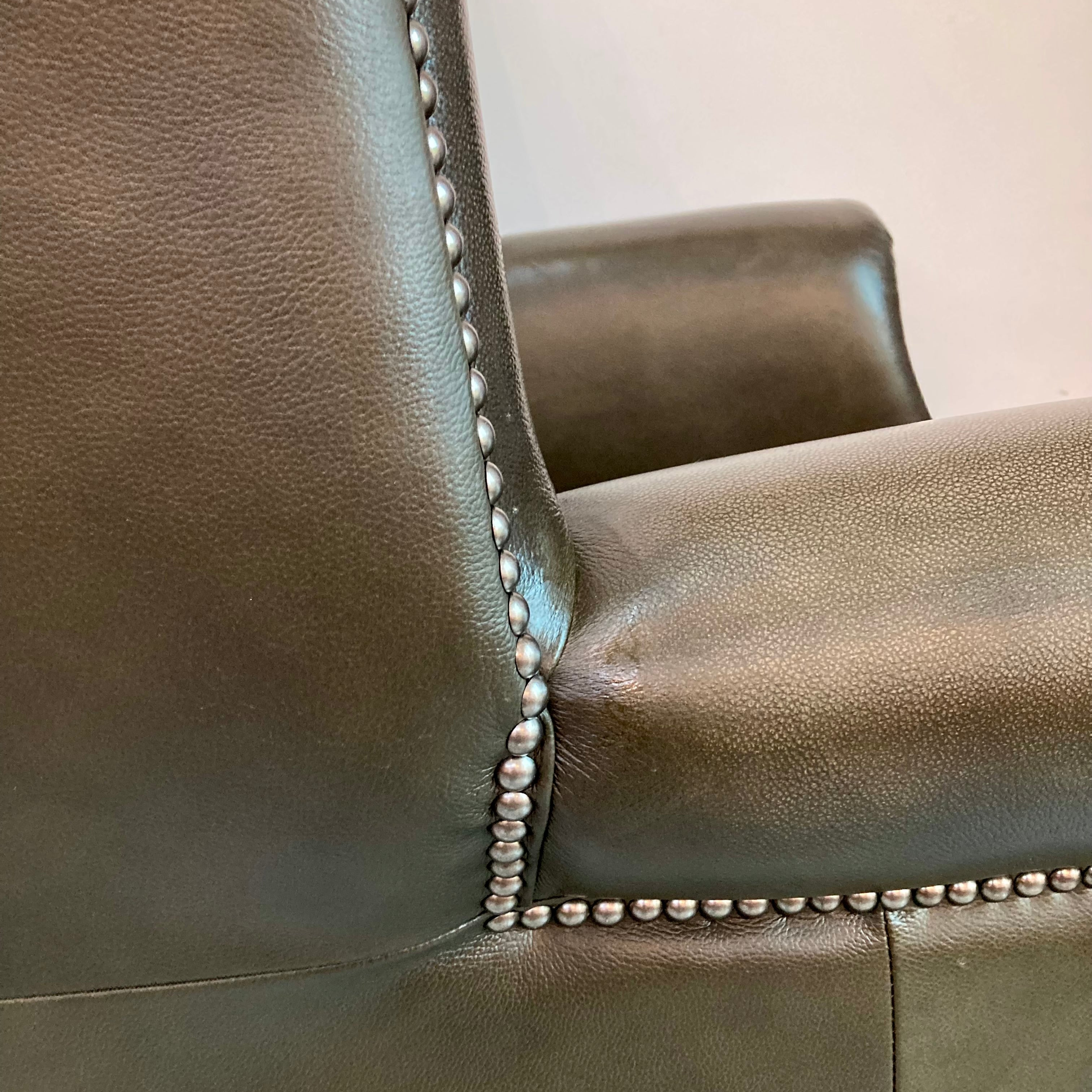 Close-up of a green leather chair with studded details.